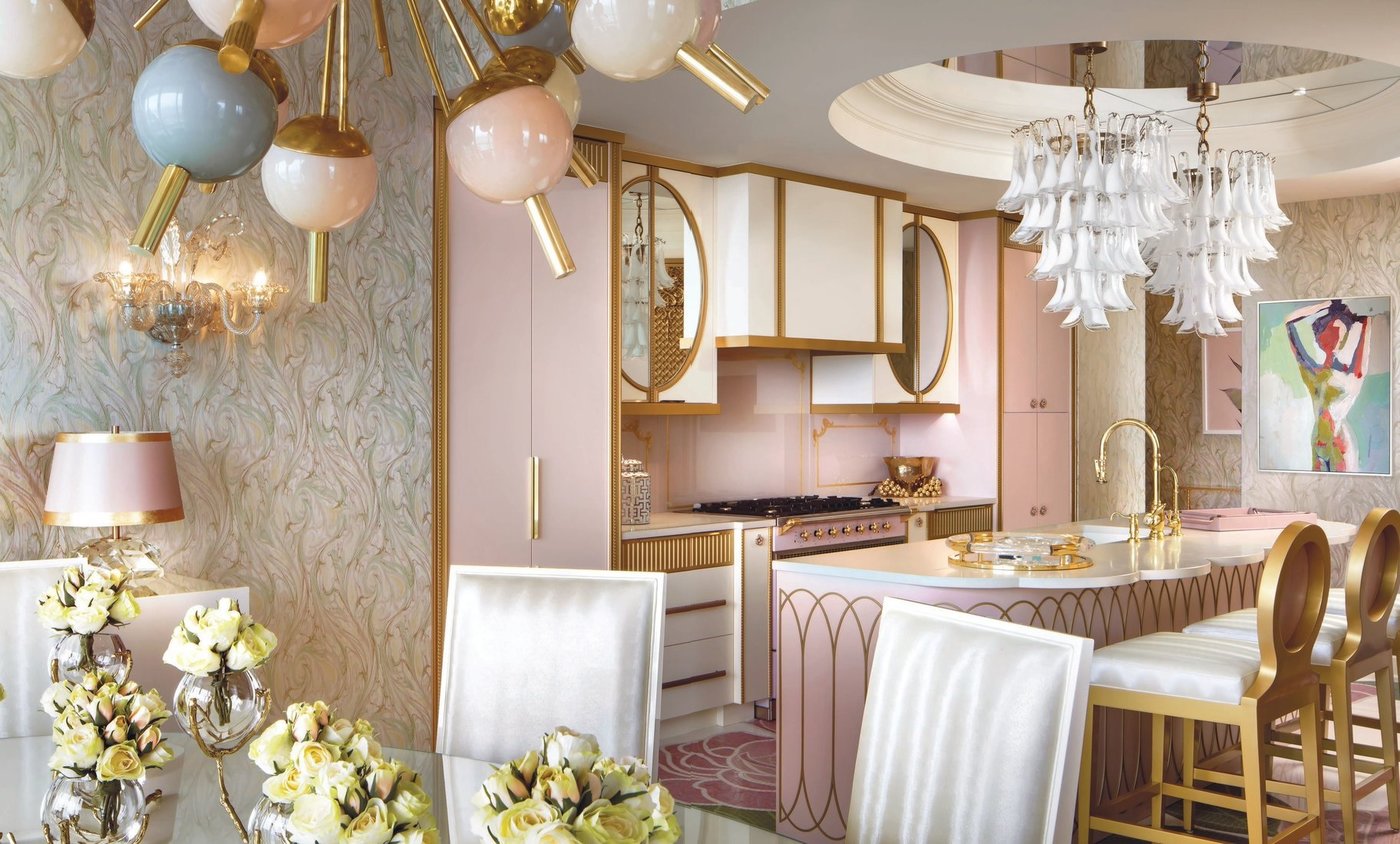 The kitchen in the residence features rose shades with golden tones and brass textures in the form of framing, fixtures and stools. Much of the furniture here and the nearby dining room was customized by Lori Morris Design. PHOTOGRAPHED BY BRANDON BARRÉ