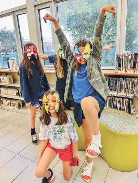 Students at the Shenandoah library wearing the masks they created in class. PHOTO COURTESY OF: PROJECTART MIAMI