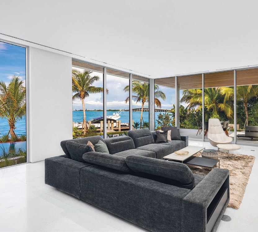 The family room features floor-to-ceiling glass windows that offer picturesque views of the water and skyline. PHOTO COURTESY OF MV GROUP